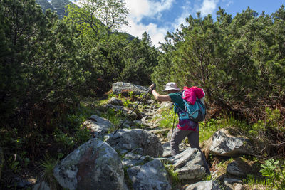 Woman standing on rock against trees