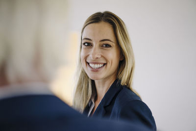 Portrait of a smiling young businesswoman in office with a colleague