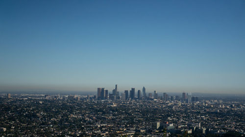 Buildings in city against blue sky