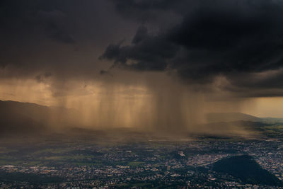 Aerial view of city against storm clouds