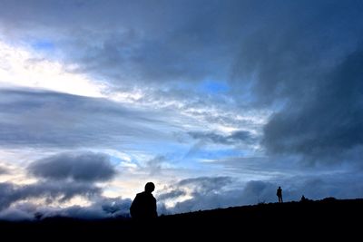 Silhouette of trees against cloudy sky