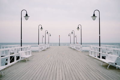 Empty street by sea against sky