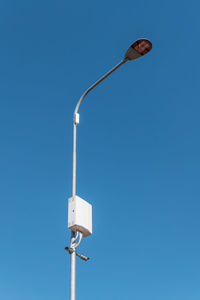 Low angle view of street light against clear blue sky