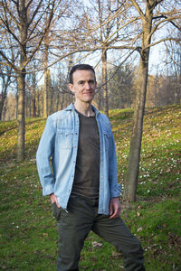 Portrait of young man standing in forest