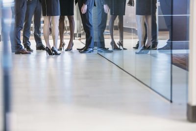 Low section of business people standing in office corridor