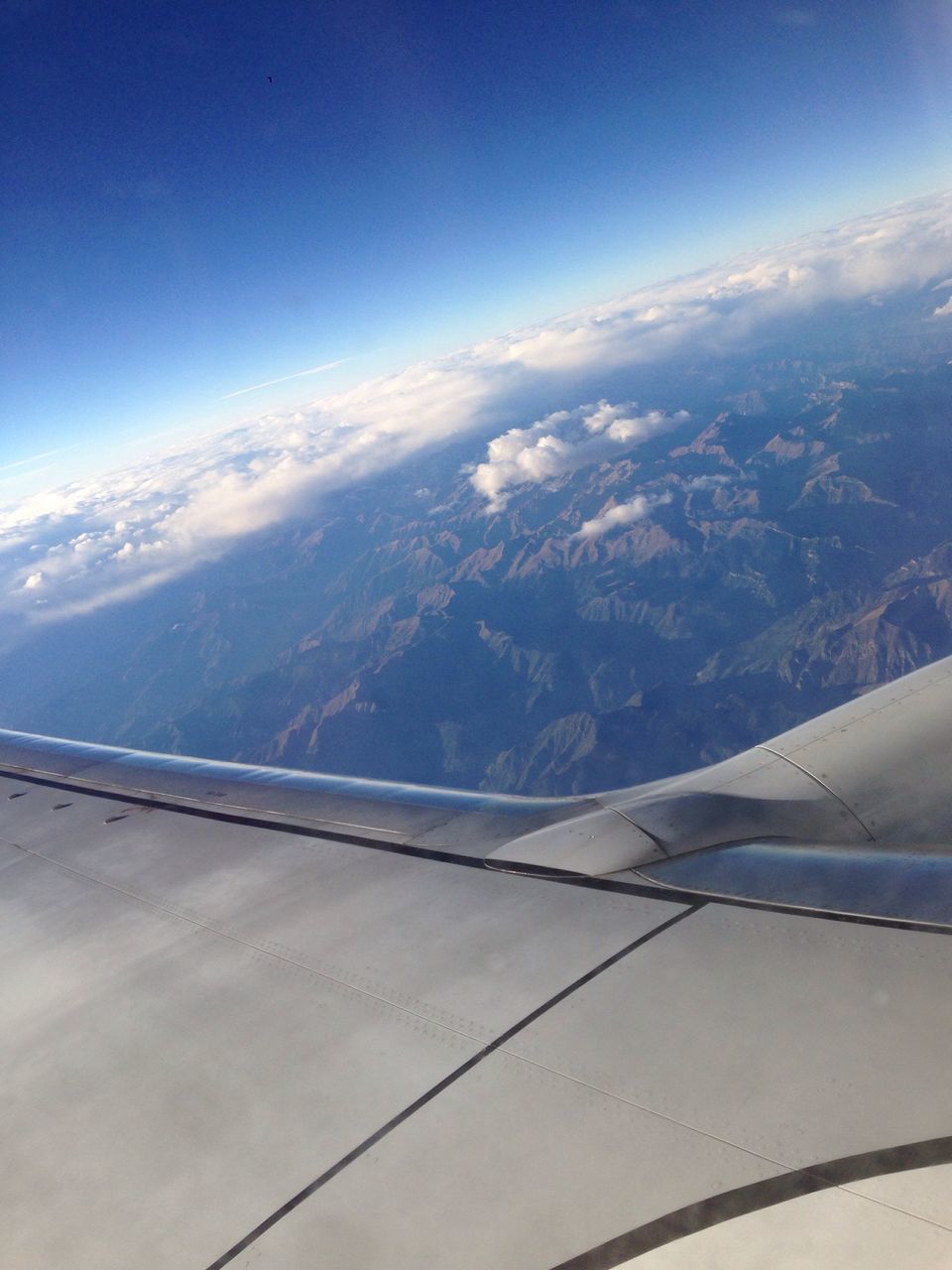 aerial view, airplane, sky, air vehicle, mountain, scenics, aircraft wing, beauty in nature, landscape, transportation, flying, part of, tranquil scene, cropped, tranquility, nature, mountain range, blue, cloud - sky, mode of transport