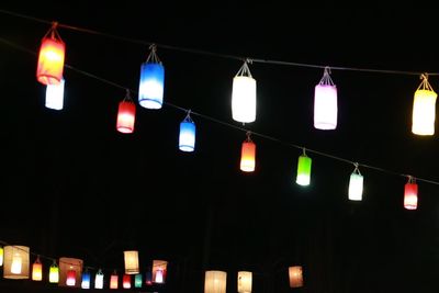 Low angle view of illuminated lanterns hanging at night