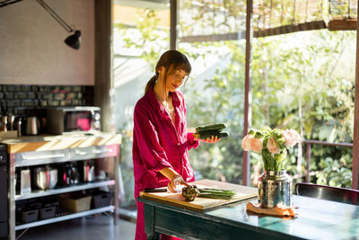 Side view of young woman preparing food at home
