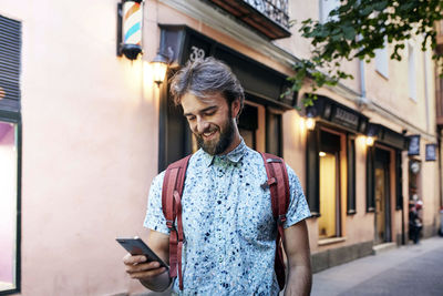 Young man using smart phone on street