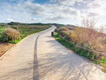 Stony tilled paved footpath at sea, dark stripe in middle divide parts for bikers and pedestrians