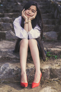 Young woman leaning on elbows while sitting on staircase