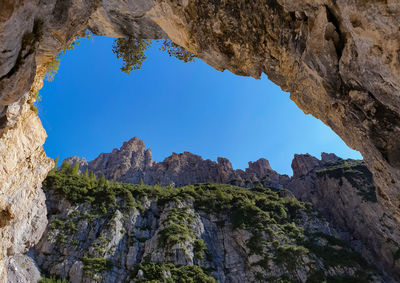 Low angle view of rocks against blue sky