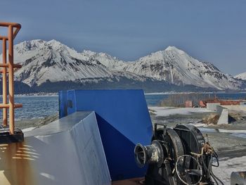 Panoramic view of snowcapped mountains by sea against sky