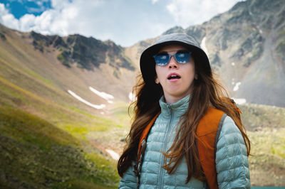 Young beautiful woman yawns. portrait of a yawning woman on a sunny morning in the mountains. summer