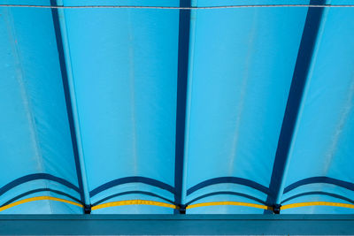 Full frame shot of metallic structure against blue wall