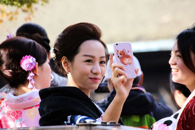 Close-up of girl photographing with mobile phone