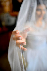 Bride seen through veil while at home