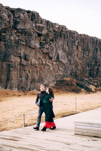 Full length of friends standing on rock