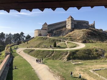 People on footpath amidst buildings against sky