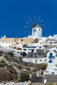  view of oia town in santorini island with whitewashed houses and traditional windmill, greece