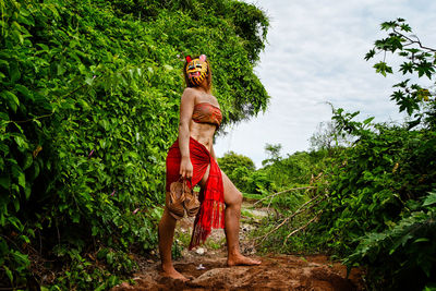 Woman wearing mask while standing in forest