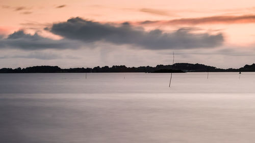 Scenic view of lake against sky at sunset