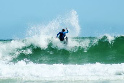 Man surfing at sea against clear sky