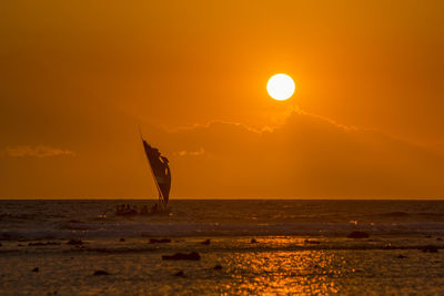 Silhouette person on beach against sky during sunset