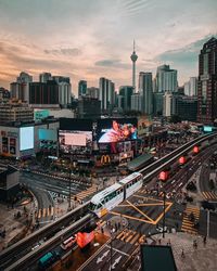 High angle view of railroad tracks by buildings in city against sky