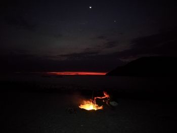 Scenic view of illuminated lights against sky at night