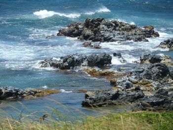 Scenic view of rocks in sea against sky