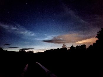 Silhouette landscape against sky at night