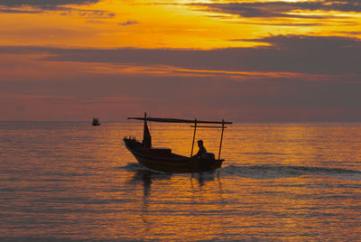 Silhouette boat in sea against sky during sunset