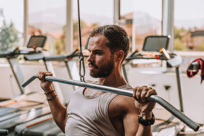 Portrait of young man lifting weights