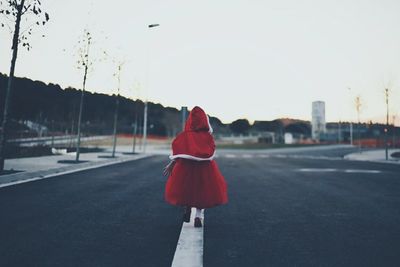 Rear view of child walking on road