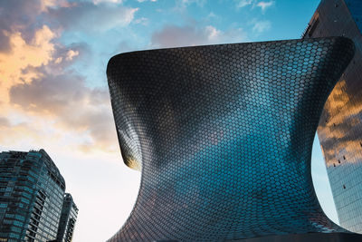 Low angle view of modern buildings against sky during sunset