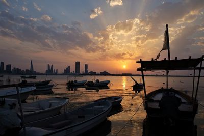 Boats moored at harbor during sunset