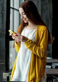 Midsection of woman holding mask while standing at home