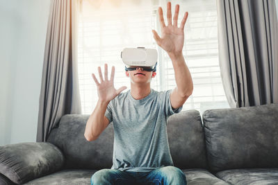 Man wearing virtual reality while sitting at home