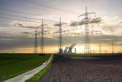 Electricity pylon on field against sky