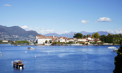 Buildings by sea against blue sky