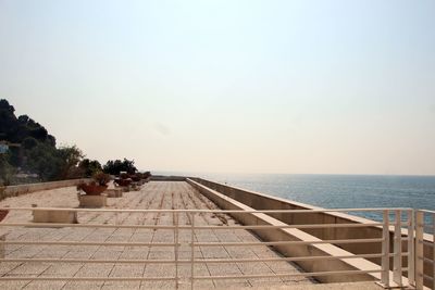 View of swimming pool by sea against clear sky