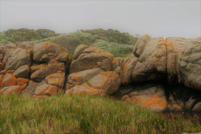 Rocks on landscape against sky