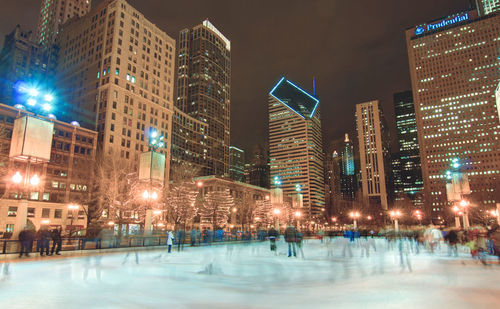 Illuminated buildings in city at night during winter