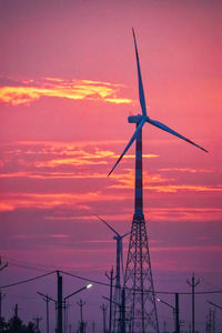Low angle view of crane against sky during sunset