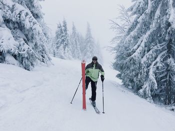 Full length of man skiing on snow covered field