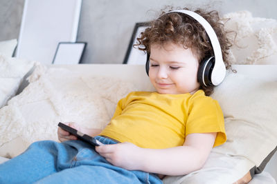 Cute baby watching cartoon on bed