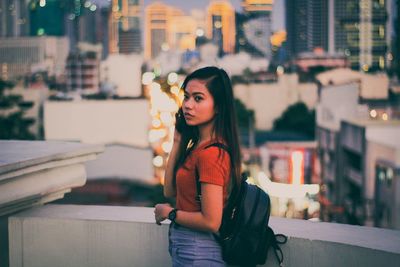 Portrait of woman standing on street at night