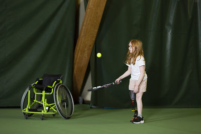 Girl with artificial leg playing tennis