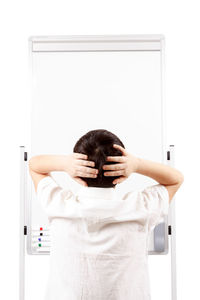 Rear view of woman standing against white door